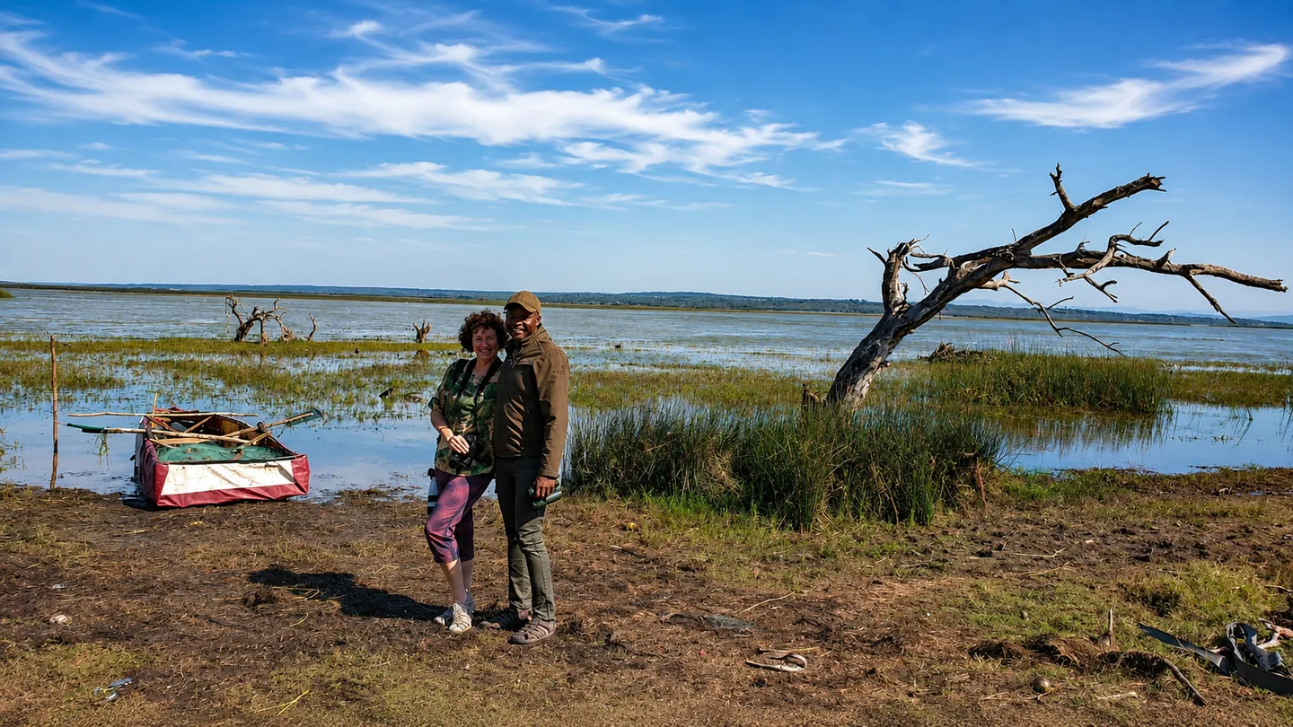 Visitors beside a wide lakeside wetland landscape